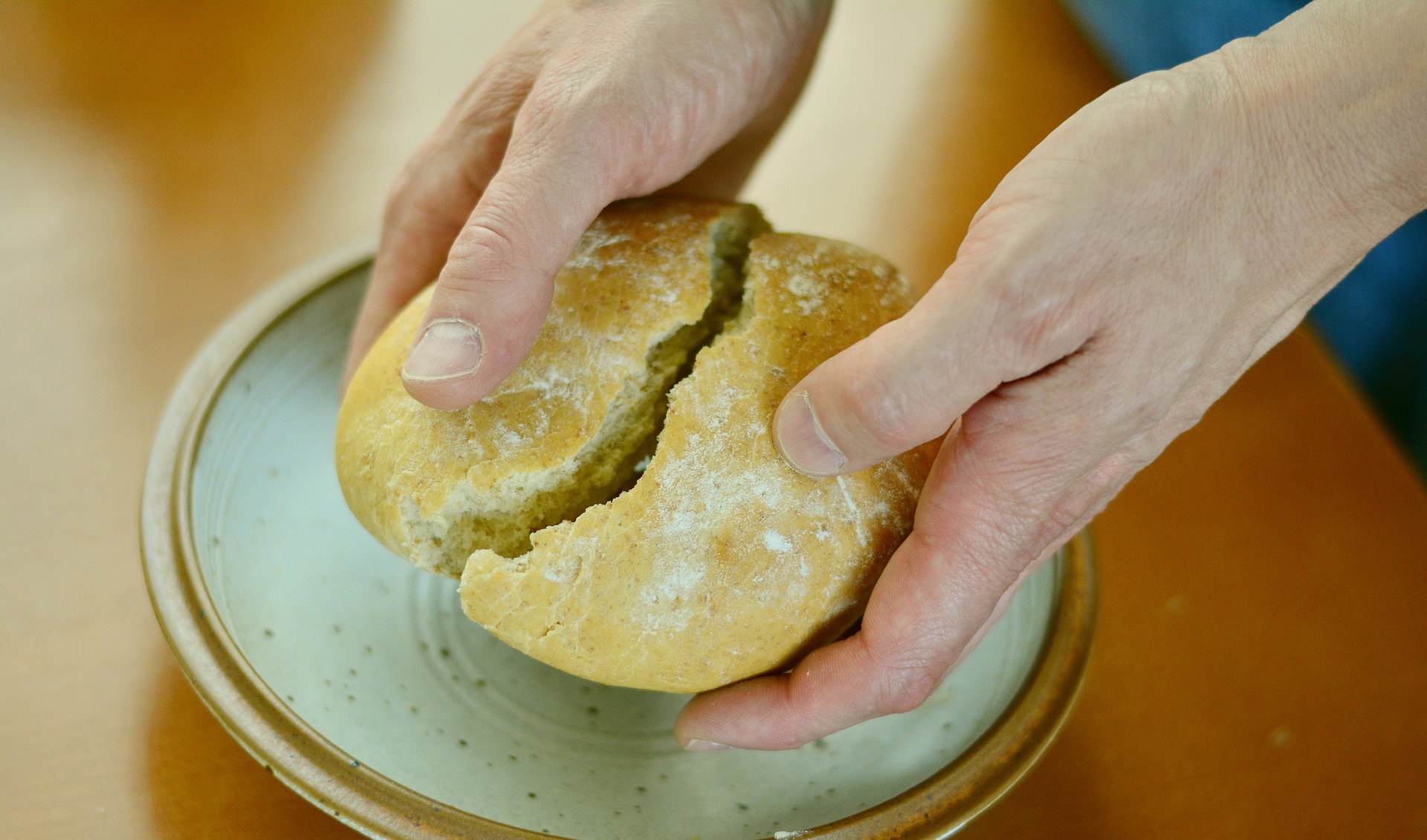 manos parten pan